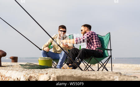 Les amis de la pêche et la consommation de bière smartphone Banque D'Images