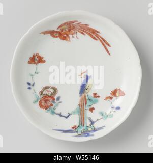 Dessus de la soucoupe d'oiseaux hoo, plat en porcelaine, peintes sur l'émail en bleu, rouge, vert, jaune, noir et or avec une paire d'oiseaux hoo, l'un dans l'air et sur un rocher avec une branche de fleurs. Style Kakiemon., anonyme, le Japon, l'c. 1670 - c. 1700, période Edo (1600-1868), Porcelaine, glaçure (matériel), de l'or (métal), la vitrification, H 2,1 cm d 6,6 cm 11,4 cm d Banque D'Images