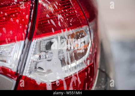 Voiture à l'aide de nettoyage de l'eau sous pression à l'extérieur. Close-up. Vue arrière de voiture. Banque D'Images