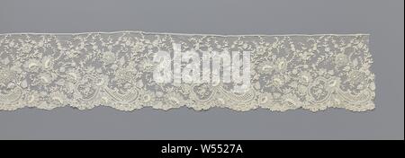 Marge de dentelle à aiguille avec marguerites et de fleurs avec pétales circulaires circulaire autour d'un coeur de fleur, de franges de couleur naturelle : dentelle aiguille dentelle de Bruxelles. Le motif récurrent est composé de trois c-volutes le long de la face inférieure de la bande, qui forment la trame d'un médaillon de l'incliné. Le médaillon est couronnée d'une daisy dans laquelle un motif en forme de goutte apparaît alors, qui se trouve le long de la face inférieure de la bande et est également constitué de c-volutes. Entre les médaillons successives avec des gouttes sont deux grandes marguerites le long de la face inférieure de la bande. D'où une longue et étroite avec la branche de fleurs Banque D'Images