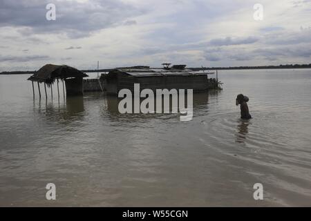 Le 26 juillet 2019, Kurigram, Bangladesh : un homme porte sa appartient à travers une eau inondées vers sa maison en Jogmoner Bhogdanga, Chor, Kurigram. Des milliers de personnes ont été déplacées par les inondations de la mousson dans le nord du pays qui a débuté plus tôt ce mois-ci. (Crédit Image : © MD Mehedi Hasan/Zuma sur le fil) Banque D'Images