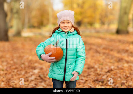 Happy little girl à la citrouille à l'autumn park Banque D'Images