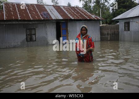 Le 26 juillet 2019, Kurigram, Bangladesh : Jomila (40), victime d'une inondation pose pour une photo devant la maison touchée par les inondations alors qu'elle vérifie le niveau d'eau après la maison réduire dans Jogmoner Bhogdanga, Chor, Kurigram. Des milliers de personnes ont été déplacées par les inondations de la mousson dans le nord du pays qui a débuté plus tôt ce mois-ci. Credit : MD Mehedi Hasan/ZUMA/Alamy Fil Live News Banque D'Images