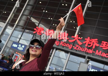 --FILE--un touriste chinois qui agitait un drapeau national chinois pose devant le port Zhuhai la plus longue du monde de la mer croisée, le pont Hong Kong-Zhuh Banque D'Images