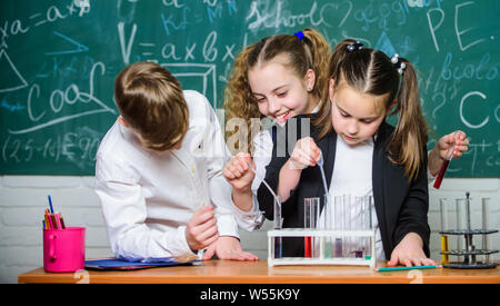 Des enfants heureux. Leçon de chimie. Les petits enfants l'apprentissage de la chimie. les étudiants en expériences en biologie avec microscope en laboratoire. L'enseignement de la chimie. Équipements en chimie. Belle journée dans le laboratoire. Banque D'Images