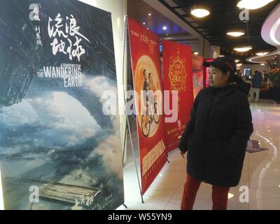 Un filmgoer chinois ressemble à une affiche du film 'La Terre' errant dans un cinéma à Shanghai, Chine, le 15 février 2019. La science-fiction de la Chine bl Banque D'Images