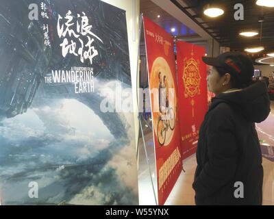 Un filmgoer chinois ressemble à une affiche du film 'La Terre' errant dans un cinéma à Shanghai, Chine, le 15 février 2019. La science-fiction de la Chine bl Banque D'Images