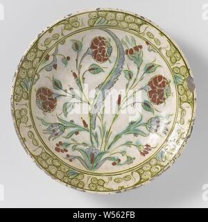 Plat d'une plante à fleurs stylisées, plat de quartz-fritware décorée d'une fleur stylisée en vert, bleu, jaune, brun et rouge sur blanc sous glaçure transparente laisse-alcali. Un motif en laine ou tourner sur le bord. Iznik., anonyme, Iznik, ch. 1575 - c. 1590, Grès, glaçure, la vitrification, H 6,2 cm d 30,9 cm Banque D'Images