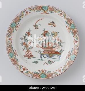 Assiette de faïence, peint multicolore Multicolore plaque peinte avec un vase chinois et panier rempli de fleurs sur une table. Le long du bord lambrequins., anonyme, Delft, c. 1750 - c. 1770, D. 22,5 cm × H 2,9 cm Banque D'Images