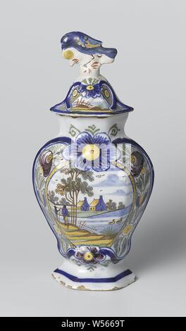 Jarre recouverte, Pot de faïence multicolores. Un cartouche avec deux maisons dans un paysage aux couleurs bleu, jaune, vert, brun et violet est peint sur le pot. Le pot appartient à une tasse avec jambes identiques., De Vergulde Blompot, Delft, ch. 1810 - c. 1840, faïence, émail étain, h 21,7 cm × w 14,0 cm × 10,0 cm d Banque D'Images