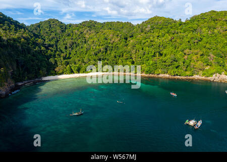 Drone aérien vue de longtail traditionnels bateaux de pêche dans une baie sur une petite île tropicale, l'île de la caverne (Mergui, Myanmar), Banque D'Images