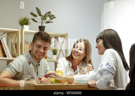 Smiling nutritionniste montrant un plan sain de régime et de fruits au patient. Jeune couple consulter un médecin pour avoir un tableau de recommandations. Style de vie sain et de l'alimentation, de la médecine et du traitement. Banque D'Images