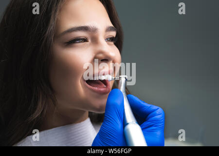 Processus d'utilisation de brosse dentaire comme une étape de la procédure de nettoyage dentaire professionnel en clinique, Close up Banque D'Images