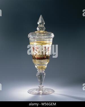 Gobelet avec Couvercle fait Zwischengold de verre, avec un baril de poudre avec un trophée d'armes nucléaires et d'un panier de fleurs. En vertu d'un brassard double balustre à facettes en forme de tronc. Facettes polyvalent, voûtée en forme d'entonnoir calice au fond. Couvercle à facettes, le bourgeon faite d'un cône et nodus aux multiples facettes. Dans le fond du calice un médaillon doré avec diamants entourés d'une bordure de palmettes. Sur le calice, entre une feuille d'or de la vigne et une tuyauterie en argent, rouge, brun et vert, un baril de poudre avec un trophée d'un côté et d'un panier de fleurs sur l'autre. Le médaillon dans le fond se répète dans le couvercle. Bords Kit Banque D'Images