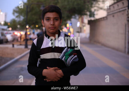 25 juillet 2019, Mashhad, Iran : Ali, 13 ans, un enfant travailleur pose avec sa marchandise, il a commencé à travailler autour de 2 ans, il étudie pendant le travail.Le travail des enfants est un problème grave en Iran, estimé entre 3 à 7 millions de dollars, dont 60 000 enfants de rejoindre chaque année. Credit : Mohammad Javad/Abjoushak SOPA Images/ZUMA/Alamy Fil Live News Banque D'Images