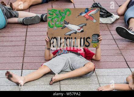 Munich, Allemagne. 26 juillet 2019. Un enfant participant à une matrice dans la Rébellion organisée par l'Extinction du groupe est titulaire d'un panneau à l'Aéroport International de Munich pour protester contre le transport aérien. Pendant une vague de chaleur en Europe qui a battu des records, des militants de l'Extinction du groupe ont organisé une rébellion à mourir dans l'Aéroport International de Munich au début des vacances d'été afin de mieux faire connaître les émissions de CO2. Credit : ZUMA Press, Inc./Alamy Live News Banque D'Images