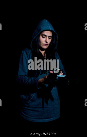 Portrait de jeune femme de mettre des gants dans le gymnase avec des gants sur fond noir Banque D'Images