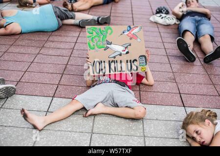 Munich, Allemagne. 26 juillet 2019. Un enfant participant à une matrice dans la Rébellion organisée par l'Extinction du groupe est titulaire d'un panneau à l'Aéroport International de Munich pour protester contre le transport aérien. Pendant une vague de chaleur en Europe qui a battu des records, des militants de l'Extinction du groupe ont organisé une rébellion à mourir dans l'Aéroport International de Munich au début des vacances d'été afin de mieux faire connaître les émissions de CO2. Credit : ZUMA Press, Inc./Alamy Live News Banque D'Images