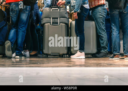 Les passagers en attente pour l'embarquement d'un aéroport pour un vol d'attente, les voyageurs à l'arrivée, de retour de vacances aux plus mauvais jours, l'air encombré Banque D'Images