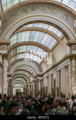 Une foule de visiteurs à pied les galeries d'art de la célèbre et populaire du Louvre et à admirer les magnifiques peintures. Banque D'Images