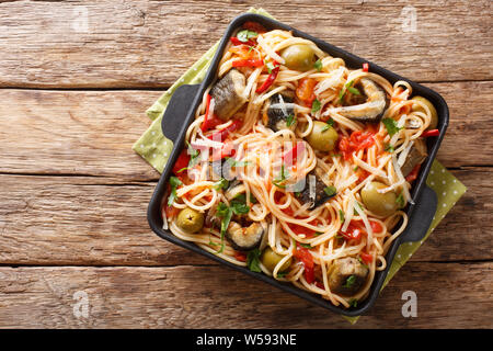 Les pâtes italiennes avec eel, olives, poivre et sauce tomate gros plan sur une assiette sur la table. haut horizontale Vue de dessus Banque D'Images