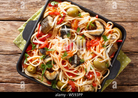 Spaghettis à l'anguille poisson frit, des olives, du poivre et de la sauce tomate sur une assiette sur la table. haut horizontale Vue de dessus Banque D'Images