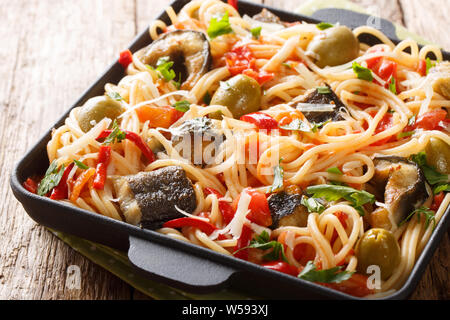 Spaghettis à l'anguille poisson frit, des olives, du poivre et de la sauce tomate sur une plaque horizontale sur la table. Banque D'Images