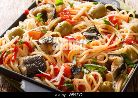 Les pâtes spaghetti à l'anguille, poisson grillé, olives poivre et sauce tomate libre sur une plaque sur la table horizontale. Banque D'Images