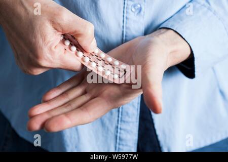 Mains tenant l'hormonothérapie substitutive (HTS) comprimés. HRT pilules sont des hormones de synthèse utilisé pour traiter les femmes ménopausées. Ils contrer le déficit hormonal qui se produit à la ménopause. Banque D'Images