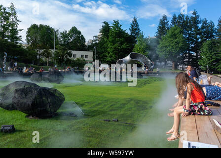 La vapeur froide avec les touristes japonais et étrangers dans Midtown jardin pelouse de Tokyo Midtown, Roppong, Japon, 2019 Banque D'Images