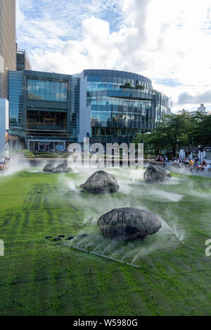 La vapeur froide avec les touristes japonais et étrangers dans Midtown jardin pelouse de Tokyo Midtown, Roppong, Japon, 2019 Banque D'Images