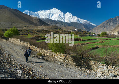 Deux hommes népalais à marcher vers la ville de Kagbeni, Upper Mustang région, le Népal. Banque D'Images