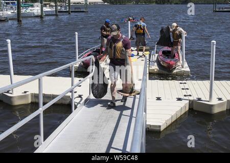 Les Marines américains de Marine Corps Air Station New River et Camp Lejeune retour à la marina pour se débarrasser de déchets à partir de la voie navigable de Gottschalk Marina, Camp Lejeune, N.C, 25 juillet 2019. Le 25 juillet 2019. Dans l'effort de garder Camp Lejeune et ses environs propre, le seul programme Marine a organisé une occasion pour la communauté de se regrouper pour collecter et éliminer correctement les débris et les résidus qui se seraient échoués sur le littoral. (U.S. Marine Corps photo par le Cpl. Tiana Boyd). () Banque D'Images