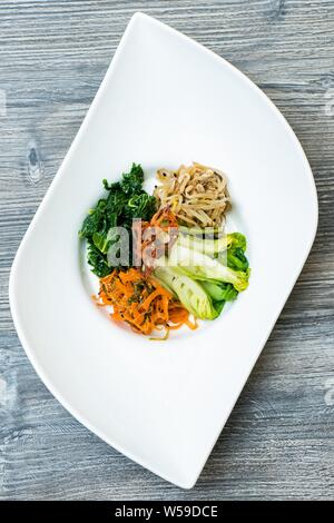 Dose verticale de légumes en tranches et de nouilles sur un blanc assiette moderne Banque D'Images