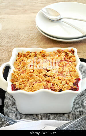 Framboise crumble de bleuets frais cuit pour deux en petite cocotte en format vertical. De délicieux petits fruits frais de saison dessert. Banque D'Images