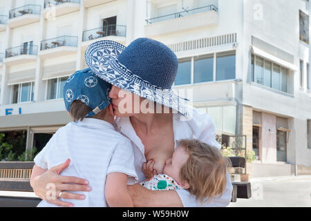 Arrière-plan de l'allaitement. Deuxième enfant dans la famille. Woman hugging allaitement de l'enfant aîné. Arrière-plan de la maternité. Belle jeune mère allaitait tout en serrant teenage boy Banque D'Images