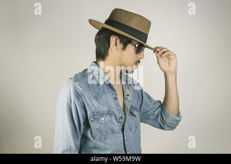Portrait Man en jeans chemise ou chemise en jean et lunettes ou lunettes et Touch Hat. L'homme en jeans chemise ou chemise en Jean marron avec chapeau de paille portent des gla Banque D'Images