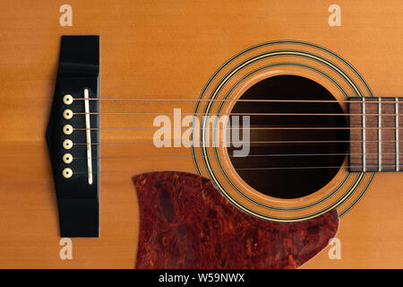 Fermer macro-vision des frettes les six et le son trou sur un corps de guitare en bois acoustique Banque D'Images