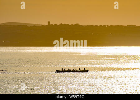 Newlyn, Cornwall, UK. 27 juillet 2019. Météo britannique. Le port de Newlyn rameurs de concert une fois dehors au soleil pour un exercice tôt le matin sur la mer à Mounts Bay. Simon crédit Maycock / Alamy Live News. Banque D'Images