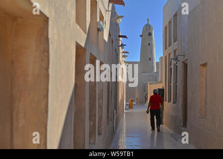 AL WAKRAH (Qatar) - 5 février 2016 : un travailleur expatrié est en marche vers la mosquée de la vieille Wakrah souq. Prises la fin d'un après-midi d'hiver Banque D'Images