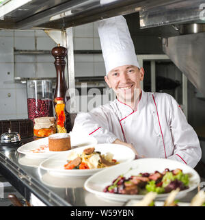 Portrait d'un chef avec des aliments cuits dans la cuisine dans le restaurant Banque D'Images
