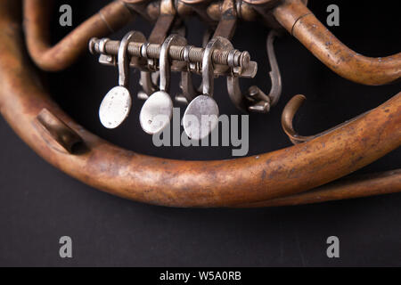 Les tuyaux de bronze, soupape, les principaux éléments mécaniques cor sur fond noir. Bon modèle, instrument de musique d'invite. Banque D'Images