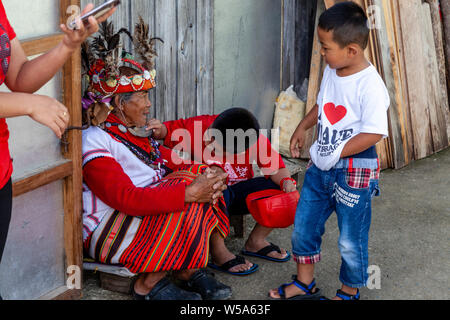 Un jeune garçon est fasciné par le Costume porté par une femme, Tribal d'Ifugao Banaue, Luzon, Philippines Banque D'Images