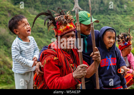 Une famille dont un enfant effrayé posent avec une tribu de Banaue, Ifugao, Luzon, Philippines Banque D'Images