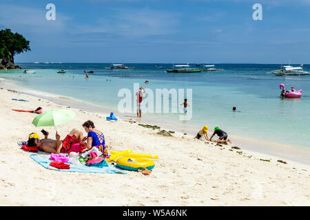 Une famille de détente sur Alona Beach, Bohol, Philippines Banque D'Images