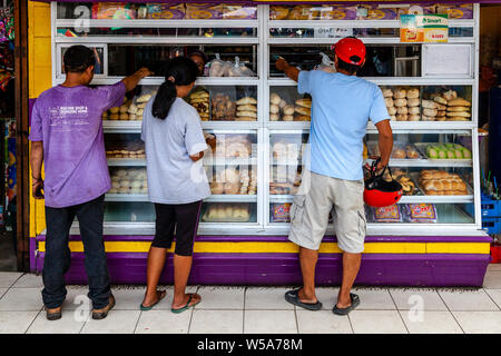 Les gens d'acheter des gâteaux d'une boulangerie, la ville de Tagbilaran, Bohol, Philippines Banque D'Images