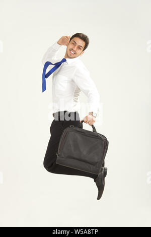 Homme d'affaires sautant dans l'air et souriant Banque D'Images