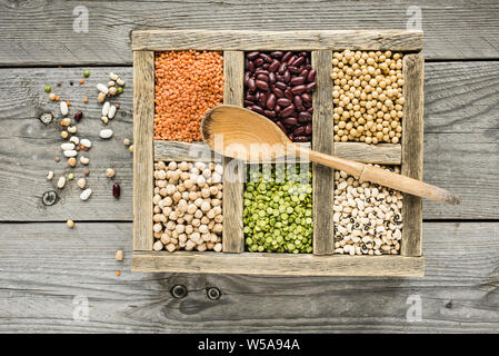 Sélection de légumes secs dans les compartiments en bois sur une table en bois rustique Banque D'Images