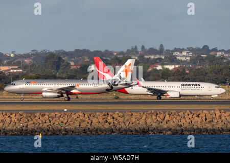 Jetstar Airways Airbus A320 bimoteur avion de passagers à l'aéroport de Sydney avec un Boeing 737 de Qantas. Banque D'Images