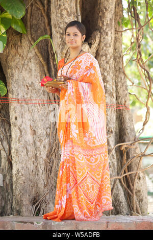 Femme adorer un arbre sacré Banque D'Images